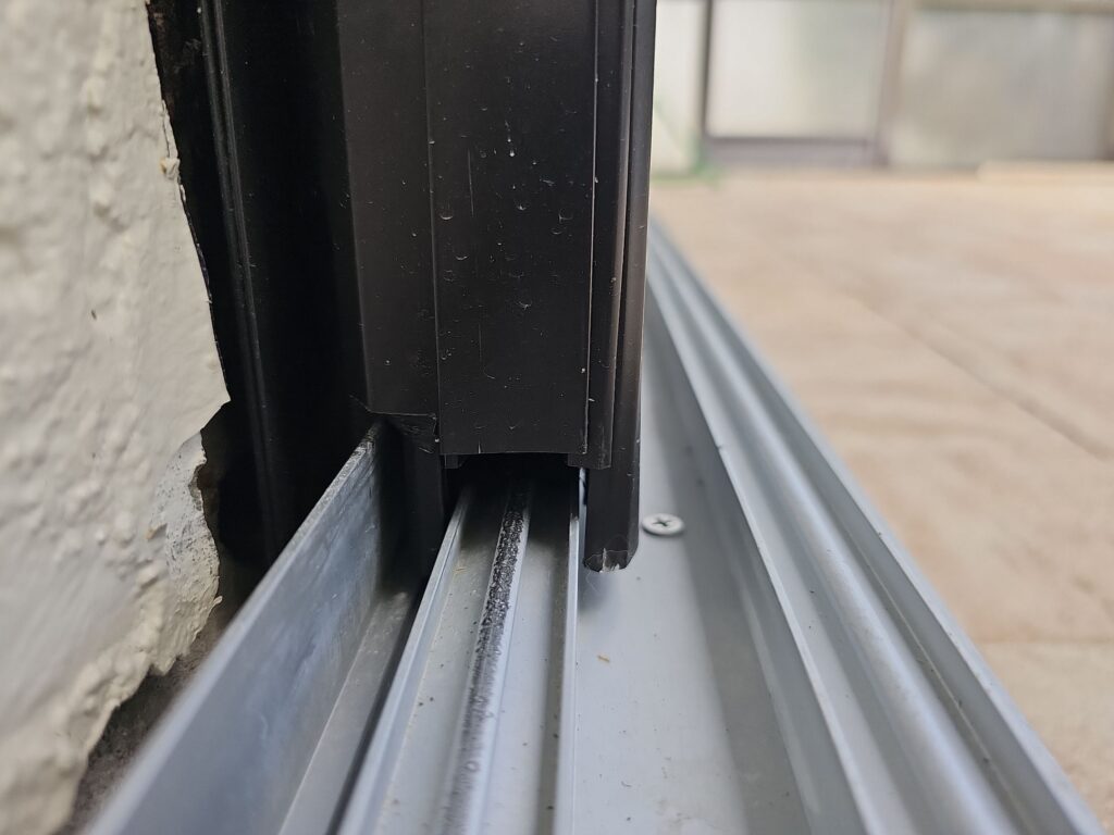 a metal window frame with a black metal strip 